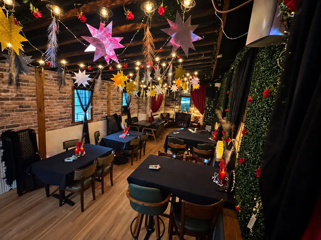 Ivy Room tables beneath hanging stars and string lights at The Oak & Ivy Taphouse