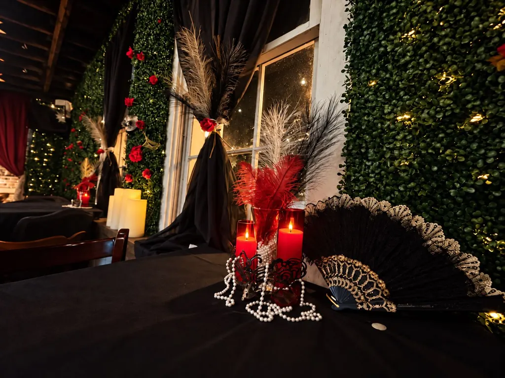 Red candles, feathers, pearls and a black fan on a Murder Mystery table at The Oak & Ivy Taphouse