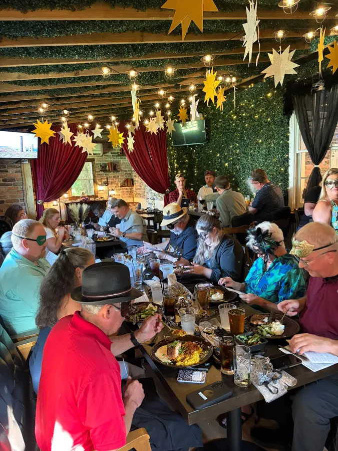 Masked guests dining and playing detective at a Murder Mystery Dinner